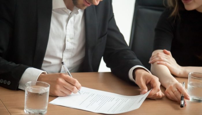 Homem-de-terno-assinando-um-documento.jpg Homem-de-terno-assinando-um-documento.jpg