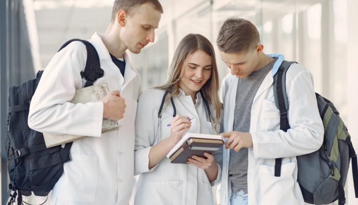 estudantes-com-jaleco-olhando-para-um-caderno.jpg estudantes-com-jaleco-olhando-para-um-caderno.jpg