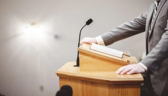 male-formal-outfit-preaching-holy-bible-from-tribune-altar-church-1-scaled.jpg