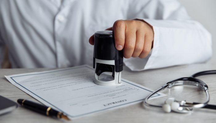 medico-em-consultorio-medico-publico-carimbando-documento-medico.jpg